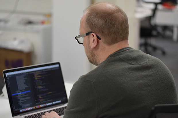 Shaun Hare, Senior Digital Developer, working at a MacBook