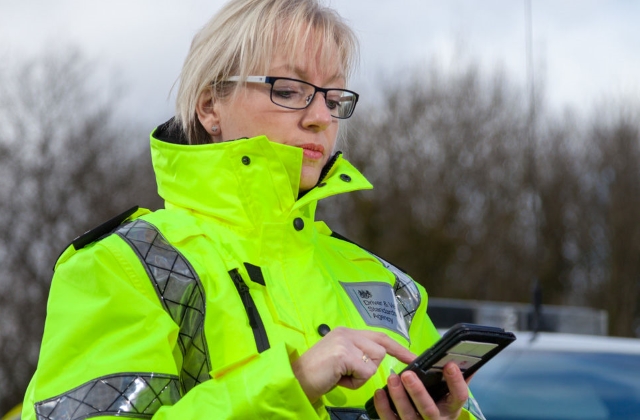 A traffic examiner using a smartphone